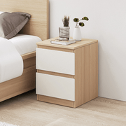 Molise white and oak two drawer bedside table beside a bed