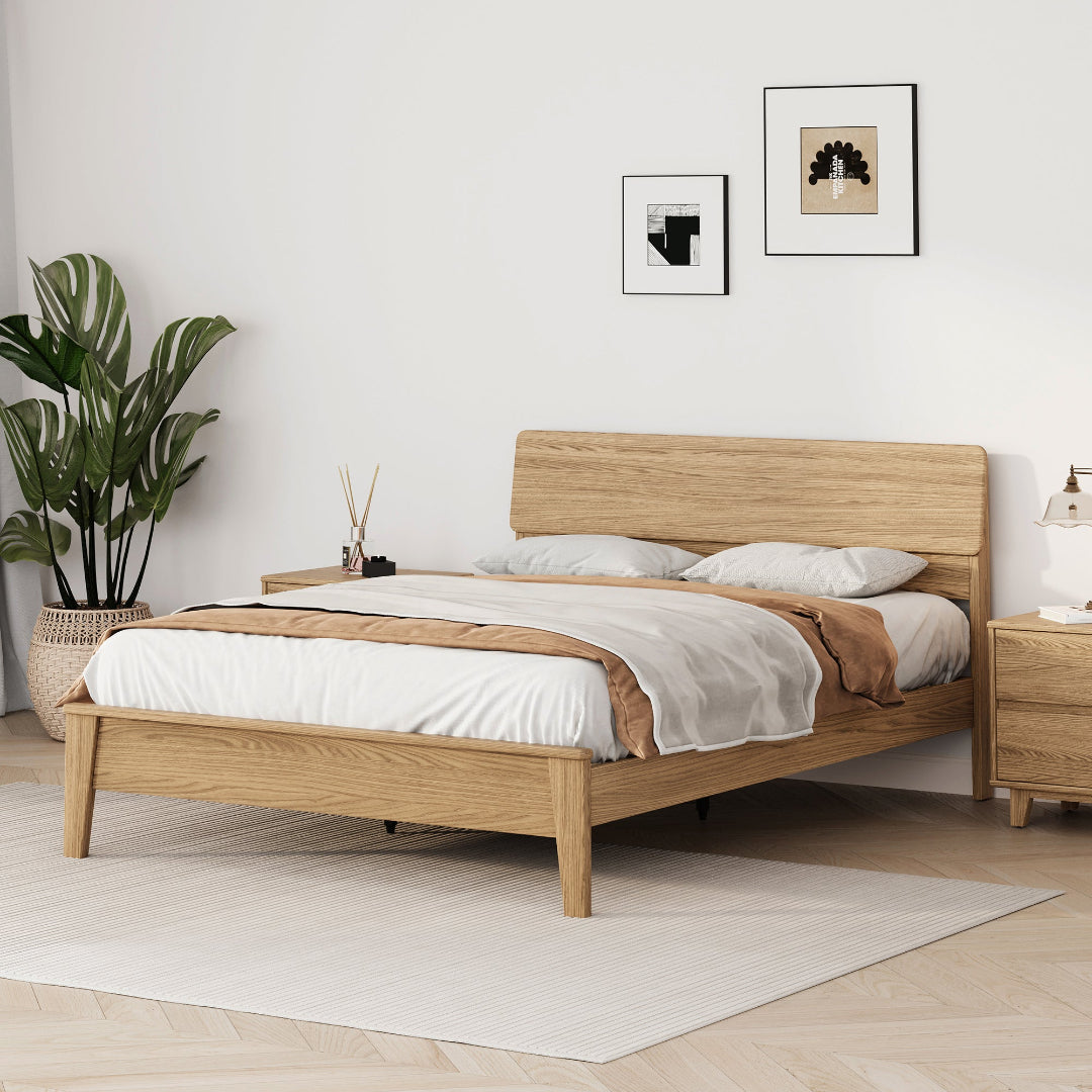 Arezzo solid wood bed frame in natural finish in a plant-filled bedroom