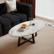 Morra oval marble-effect coffee table with black cross base beside a dark sofa