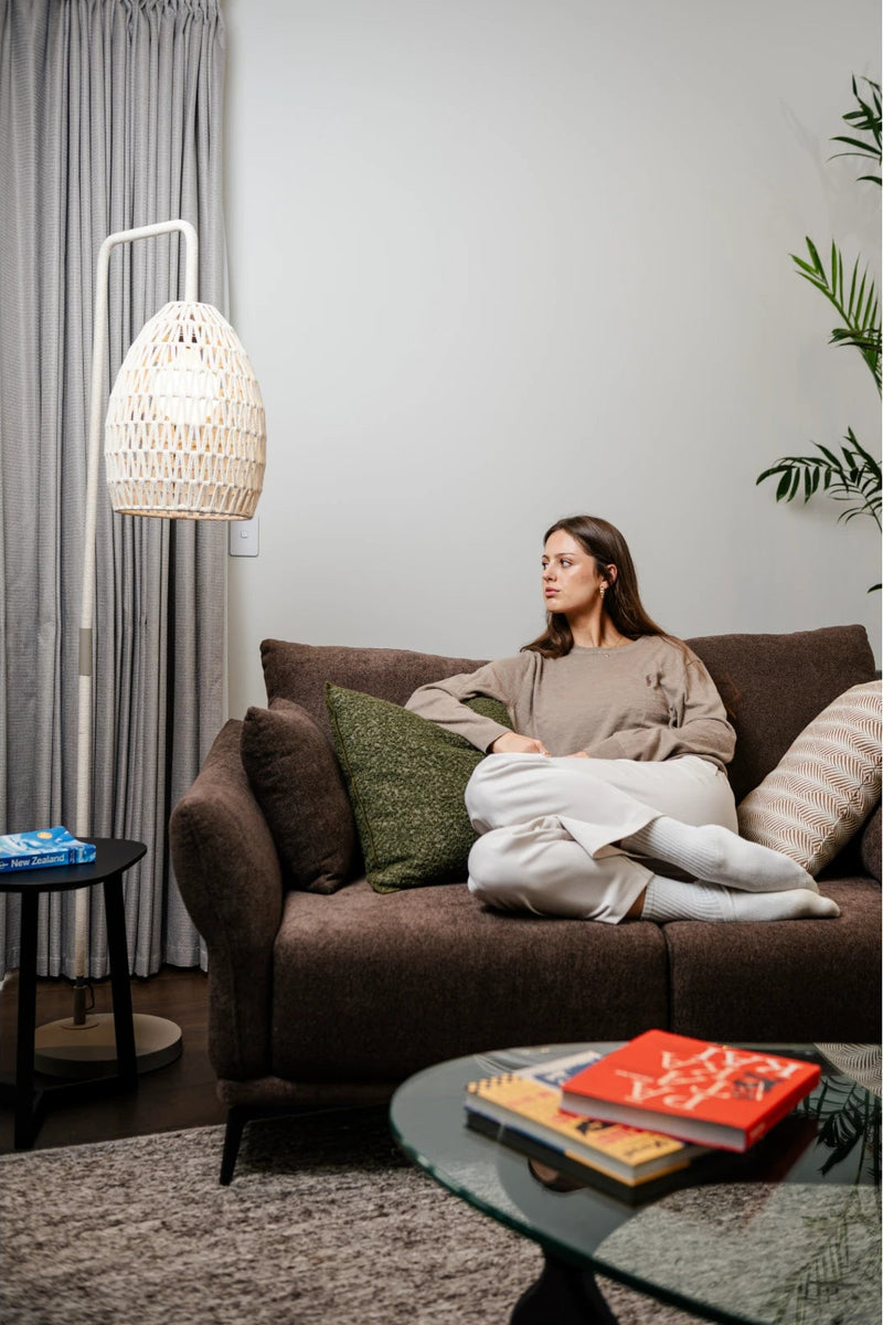 Brown fabric three seater sofa with a round coffee table in a living room