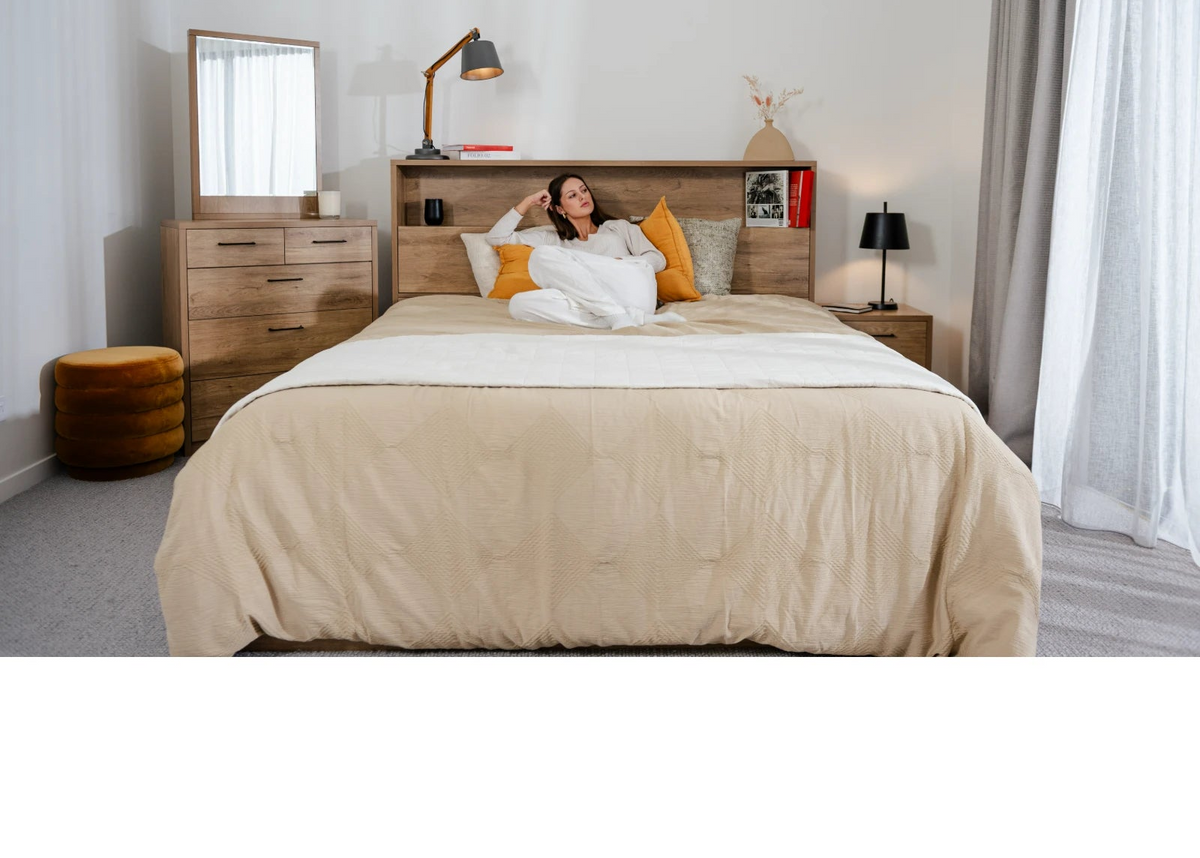 Oak bed frame with headboard storage and bedside tables in a bright bedroom
